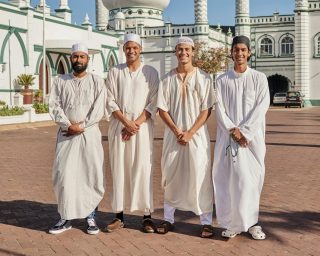 Happy, hajj and Muslim men at a mosque to pray, ramadan faith and group in Mekka together. Smile, r